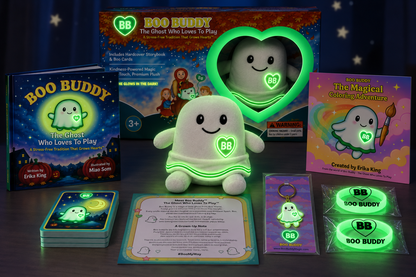 Boo Buddy toy set displayed on a dark tabletop with its packaging, book, cards, keychain, and glow-in-the-dark accessories. The main product is a small white ghost figure with a glowing green outline and a BB logo on the chest, alongside matching themed items and printed materials.