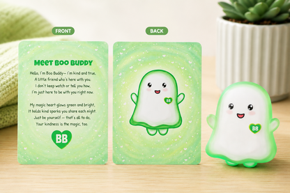 A set of cute cartoon cards and a matching physical figurine on a light wood surface. The cards show the front and back of a character named Boo Buddy with green text and illustrations, while the small figurine stands to the right.